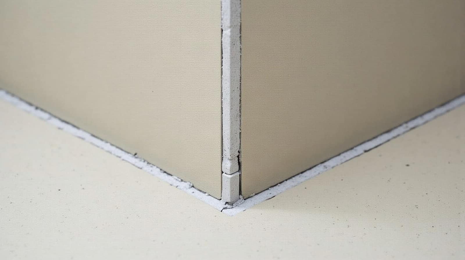 Détail d'une jonction entre un sol et un nez de marche d'escalier, tous deux finis en béton ciré de teinte identique